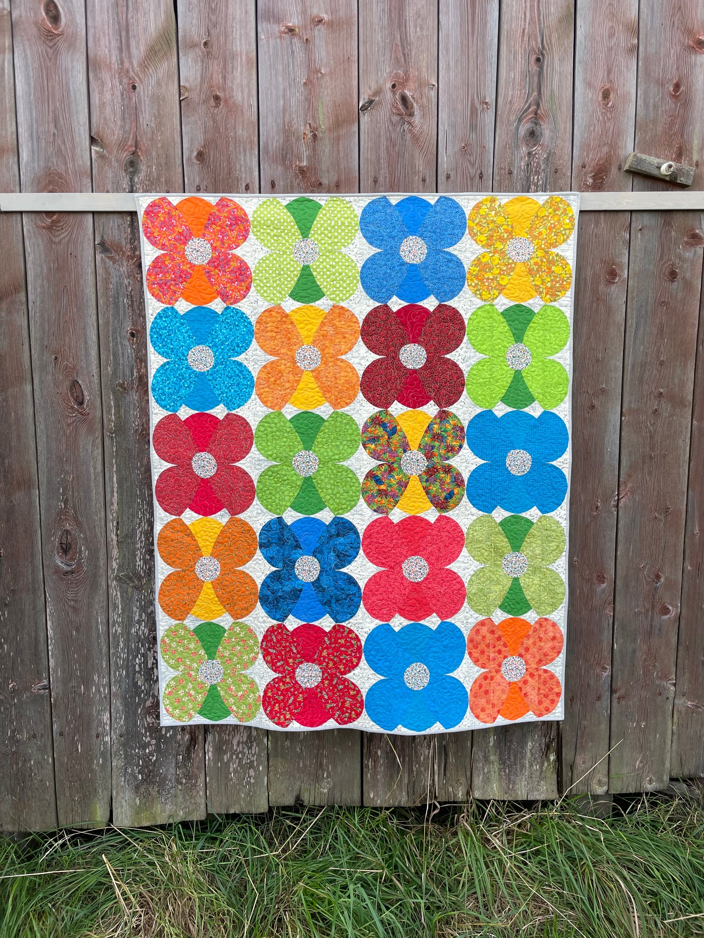Photo of quilt against an old barn