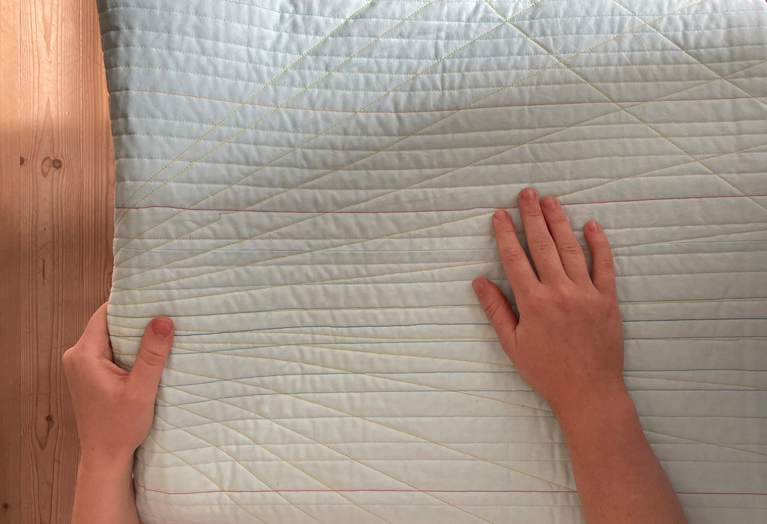 Photo of hands on a folded quilt