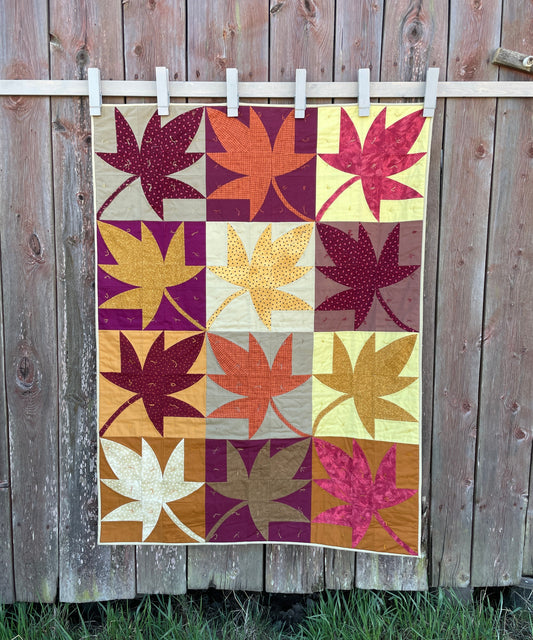 Quilt with an old barn as background
