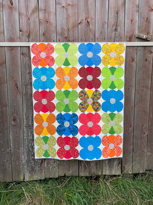 Photo of quilt against an old barn